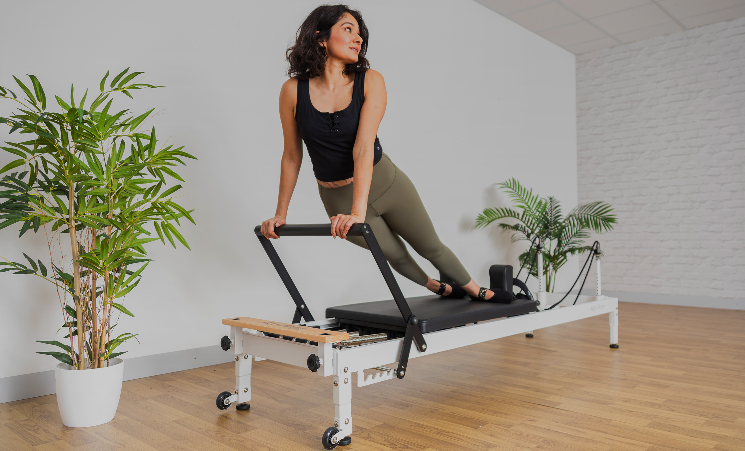 Woman using Align-Pilates white pilates reformer